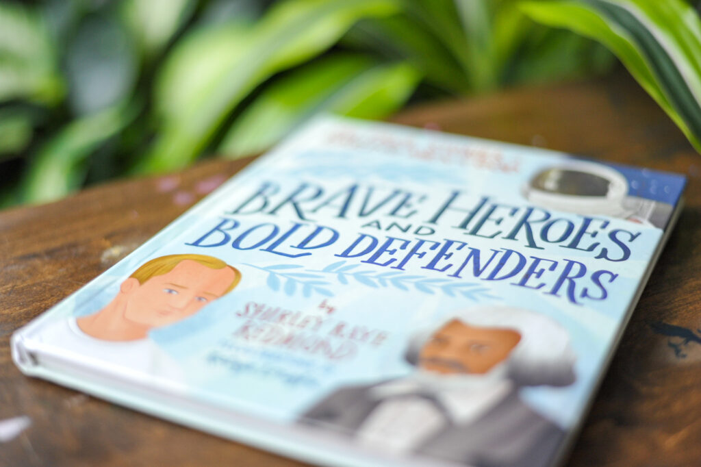 Brave Heroes and Bold Defenders book on table